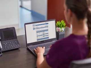 Woman on laptop viewing Sharesource remote patient management