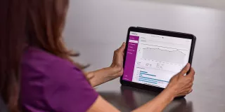 Nurse sitting with ipad in hands on table 