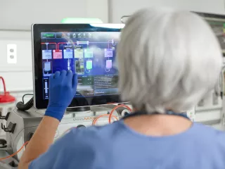 Close up of  a medical professional as she interacts with the PrisMax system screen