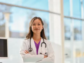 Healthcare professional stands in front of a large window